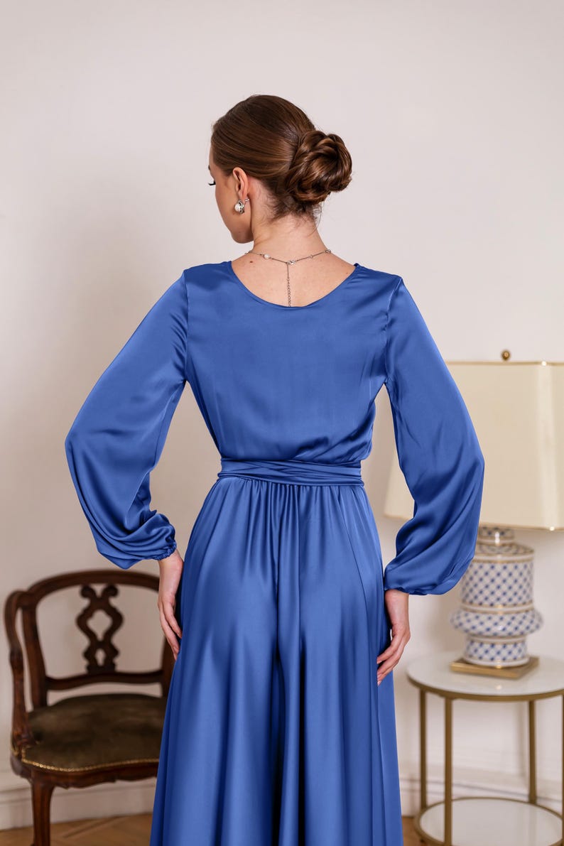 a woman in a blue dress standing in a room