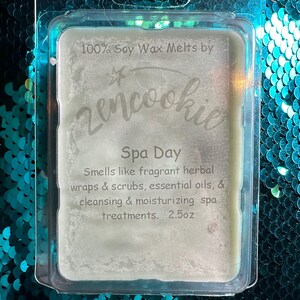 May include: A clear plastic clamshell package containing a light green soy wax melt. The label reads "100% Soy Wax Melts by Zencookie Spa Day." The scent is described as fragrant herbal wraps & scrubs, essential oils, & cleansing & moisturizing spa treatments. 2.5oz.