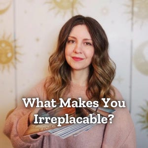 May include: A woman holding a deck of tarot cards with the text "What Makes You Irreplaceable?" The woman is wearing a pink sweater. The background is a light-colored wall with sun and star designs.