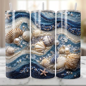 Pode incluir: Três copos de aço inoxidável com um design de conchas marinhas azul e branco. Os copos são decorados com conchas marinhas, pérolas e uma estrela do mar.