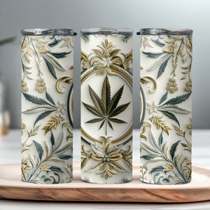 Peut inclure: Un gobelet isotherme blanc avec un motif floral décoratif et une feuille de cannabis au centre. Le design comprend des accents dorés, verts et bleus. Le gobelet mesure environ 20 cm de haut.