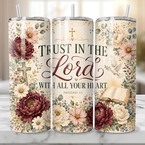 May include: A stainless steel tumbler with a floral design and the text "TRUST IN THE Lord WITH ALL YOUR HEART". The tumbler features a cross, flowers, and a dove. It includes a straw.