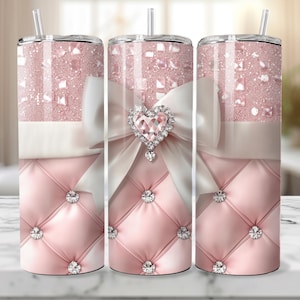 Può includere: Tre bicchieri in acciaio inossidabile rosa e bianco con uno sfondo rosa scintillante, un fiocco bianco con un grande cuore di strass e un design trapuntato rosa.