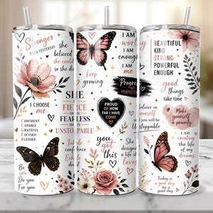 May include: Three white stainless steel tumblers with floral and butterfly designs. Each tumbler features inspirational quotes and phrases in black and rose gold, including "Stronger Than Yesterday" and "I Am Worthy."