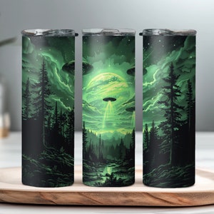 May include: Three stainless steel tumblers with a green and black design featuring a forest scene with a UFO flying over a glowing green planet.