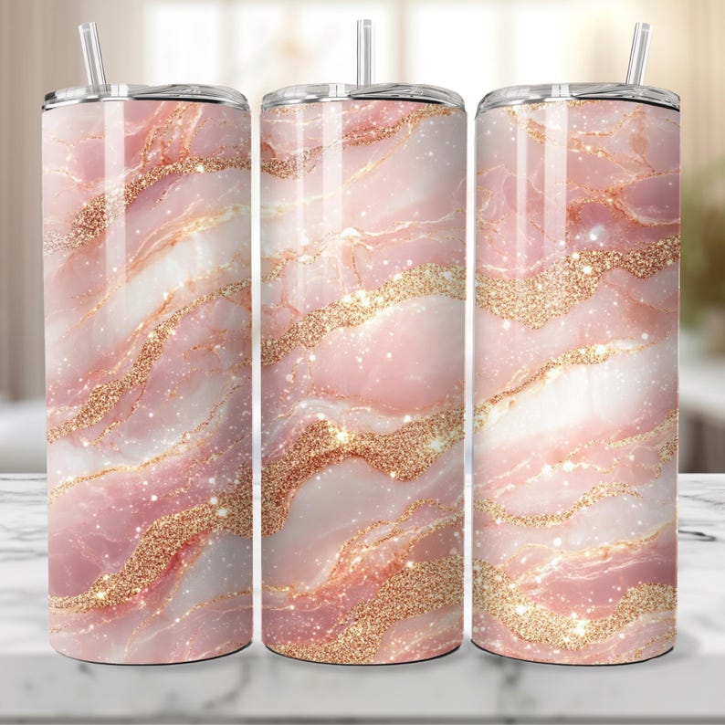 May include: Three stainless steel tumblers with a pink and gold marble pattern. The tumblers have a clear lid and a straw.