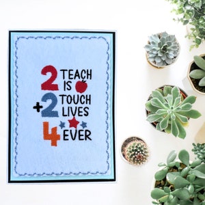 May include: A blue card with a white background and a black border. The card has an embroidered design that says "2 Teach is 2 Touch Lives 4 Ever" with a red apple and two stars.