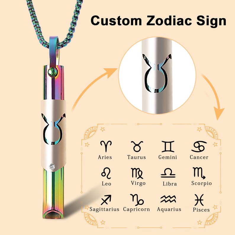 May include: A silver necklace with a pendant shaped like a Taurus zodiac sign. The pendant is a hollow cylinder with a rainbow iridescent finish. The pendant is surrounded by a silver chain. The image also shows a chart of all the zodiac signs.