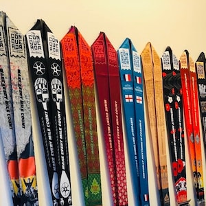 May include: A collection of colorful, patterned race finishers' ribbons with the text "Conquer the ROR" and "Make Every Mile Count".