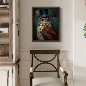 May include: A framed print of an owl wearing a blue top hat with feathers. The owl is brown and gray with yellow eyes. The background is a dark green.