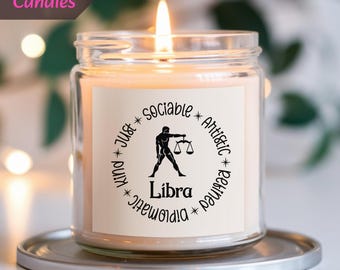 Könnte beinhalten: Ein klares Glas-Kerzengefäß mit einem weißen Etikett. Das Etikett zeigt ein schwarzes Sternzeichen Waage und den Text "Waage" umgeben von einem Kreis mit dem Text "Gesellig * Künstlerisch * Ausgeglichen * Diplomat * Gerecht * Freundlich".