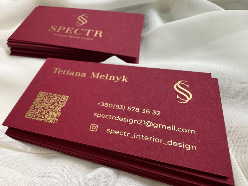 May include: Red business cards with gold lettering. The cards feature the name Tetiana Melnyk, a phone number, email address, and the text "spectr_interior_design".