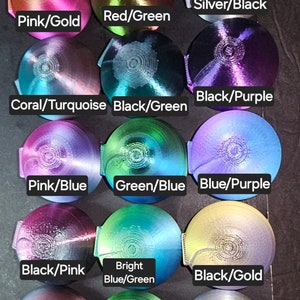 Puede incluir: Doce adornos redondos, iridiscentes, met&aacute;licos, que cambian de color con una variedad de combinaciones de colores, incluyendo rosa y oro, rojo y verde, plata y negro, coral y turquesa, negro y verde, negro y morado, rosa y azul, verde y azul, azul y morado, negro y rosa, azul brillante y verde, negro y oro, negro y rojo, verde y morado, y plata y oro.