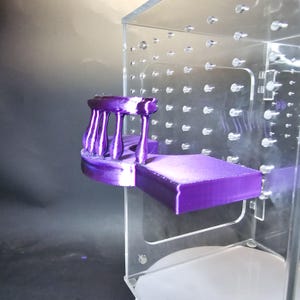 Puede incluir: Un modelo de puente de cinco arcos impreso en 3D de color morado. El modelo se encuentra sobre una plataforma morada dentro de una caja de acr&iacute;lico transparente.