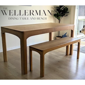 Puede incluir: Un juego de mesa y banco de madera. La mesa y el banco son de madera de color marrón claro. La mesa tiene una tapa rectangular y patas curvas. El banco es una versión más pequeña de la mesa. El texto "THE WELLLERMAN DINING TABLE AND BENCH" está en la parte superior.