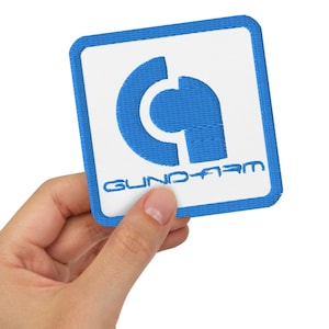 Könnte beinhalten: Ein blauer und weißer gestickter Aufnäher mit dem Logo "GUND-ARM" und einem stilisierten Buchstaben "G" in einem Kreis.