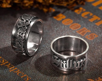 May include: Two silver rings with engraved lettering. The ring on the left says "Space" and the ring on the right says "Silly".