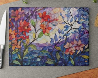 May include: A stained glass style chopping board with a floral design. The design features red, orange, pink, and blue flowers with green leaves on a purple and blue background.
