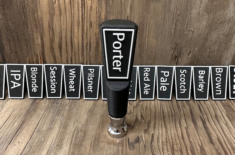 May include: Black beer tap handle with the word "Porter" in white lettering on a white background. The handle is surrounded by 12 black and white beer style labels, including IPA, Blonde, Session, Wheat, Pilsner, Red Ale, Pale, Scotch, Barley, Brown, and Stout.