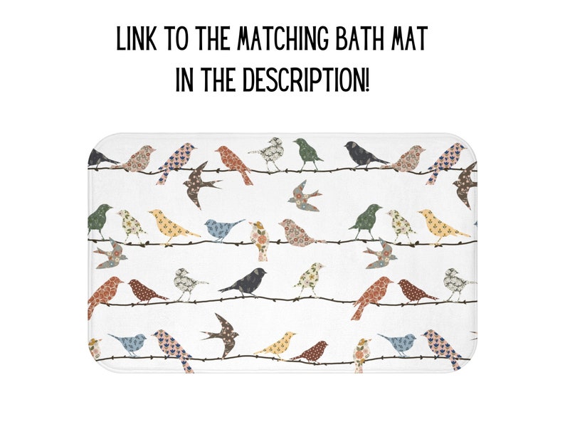 K&ouml;nnte beinhalten: Eine wei&szlig;e Badematte mit einem sich wiederholenden Muster aus bunten V&ouml;geln auf einem Drahtzaun. Die V&ouml;gel sind aus Patchwork-Stoff mit floralen und geometrischen Mustern.