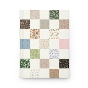 May include: A white journal with a patchwork cover featuring a variety of floral patterns in shades of green, blue, pink, and brown.