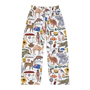 May include: White pajama pants with a colorful all-over print of Australian icons, including animals, landmarks, and food. The print includes text like "Bundy Outh", "Straya", "G'day mate!" and "Fair Dinkum".