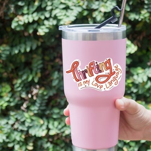 May include: Pink stainless steel tumbler with a sticker that says "Thrifting is my love language".