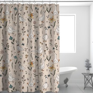 May include: A beige shower curtain with a repeating pattern of white geese, flowers, and leaves. The geese are in various poses, some are standing, some are walking, and some are swimming. The flowers are in shades of yellow, orange, and pink. The leaves are in shades of green and brown.