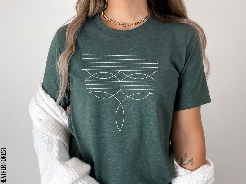 Puede incluir: Una camiseta verde oscuro con un dise&ntilde;o geom&eacute;trico blanco en la parte delantera. El dise&ntilde;o presenta una serie de l&iacute;neas horizontales y formas curvas.