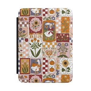 May include: A rectangular e-reader case featuring a repeating patchwork pattern of illustrations including white geese with red bows, orange pumpkins, sunflowers, tulips, butterflies, and checkered squares in shades of orange, red, and cream.