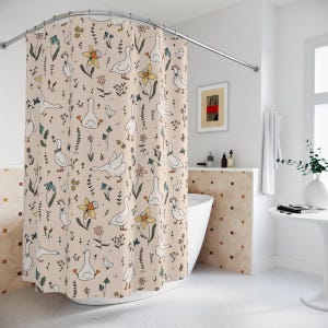 May include: A shower curtain with a beige background and a pattern of white geese, flowers, and leaves. The geese are drawn in a simple, cartoon style.