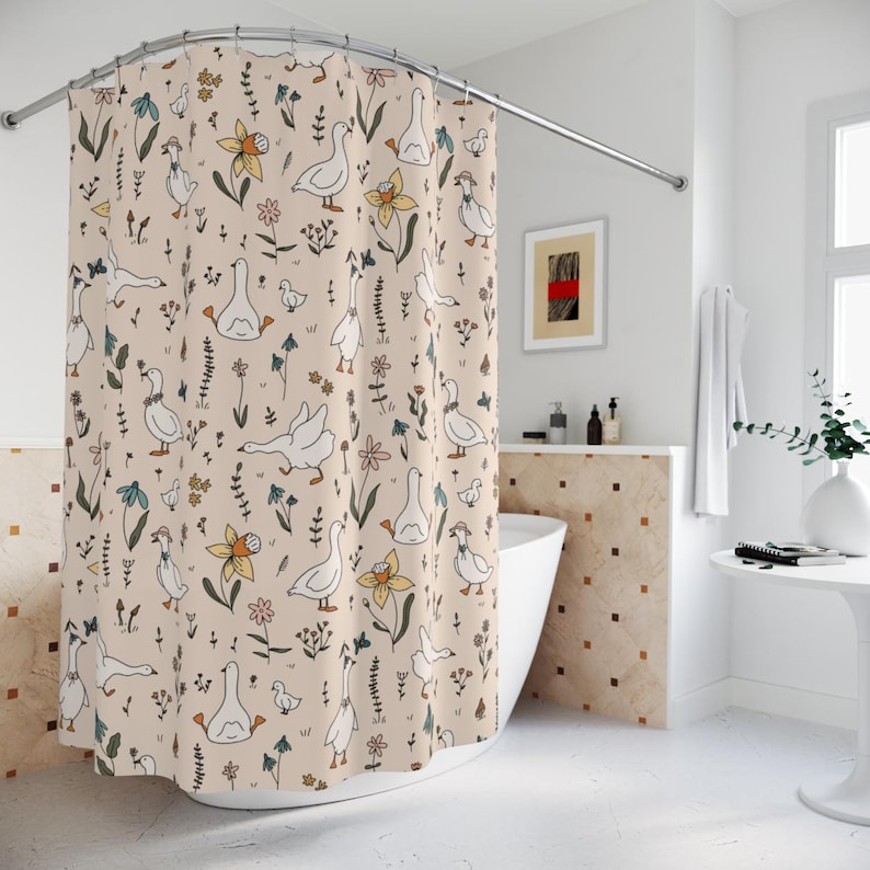 May include: A shower curtain with a beige background and a pattern of white geese, flowers, and leaves. The geese are drawn in a simple, cartoon style.