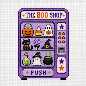 May include: A cross-stitch pattern of a purple vending machine labeled THE BOO SHOP and PUSH. The machine displays Halloween items including a jack-o'-lantern, candy corn, ghosts, a black cat, a lollipop, a witch hat, a potion, and a cauldron.