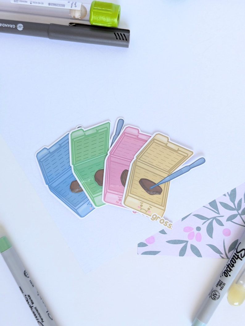 Peut inclure: Quatre autocollants color&eacute;s repr&eacute;sentant une illustration de bo&icirc;te de P&eacute;tri avec un &eacute;chantillon &agrave; l'int&eacute;rieur. Les autocollants sont dispos&eacute;s en demi-cercle avec le texte "gross." imprim&eacute; en dessous.