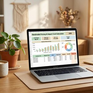 Könnte beinhalten: Ein silberner Laptop zeigt eine Tabellenkalkulation mit dem Titel Handmade Pricing & Import Cost Calculator in USD, inklusive eines Balkendiagramms für monatliche Gewinne und Umsätze, eines Kreisdiagramms und einer detaillierten Inventarliste.