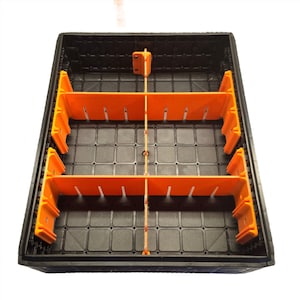 May include: A black plastic storage container with orange dividers. The dividers are arranged in a grid pattern, creating multiple compartments. The container has a textured surface and is designed for organization and storage.
