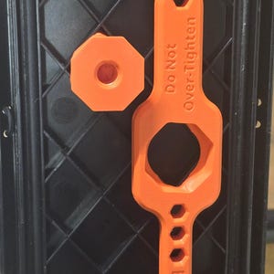 May include: Orange 3D-printed tool set, including a wrench and a hexagonal piece, inside a black case. The wrench has the text "Do Not Over-Tighten" and "Bits".