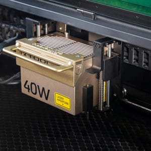 May include: A gold-colored laser cutter head with a black handle and a yellow label that reads "40W LASER APERTURE".