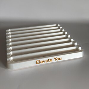 May include: White plastic tray with eight slots and the words "Elevate You" printed on the front.