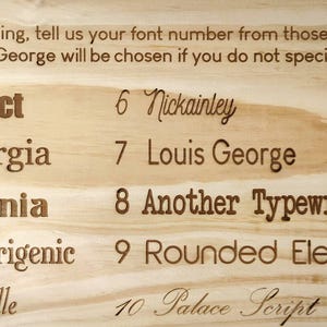 May include: A wooden board with a list of 10 font options for personalization. The fonts are numbered 1 through 10 and include Impact, Georgia, Titania, Euphorigenic, Gabrielle, Nickainley, Louis George, Another Typewriter, Rounded Elegance, and Palace Script. The text states that Louis George will be chosen if no font is specified.