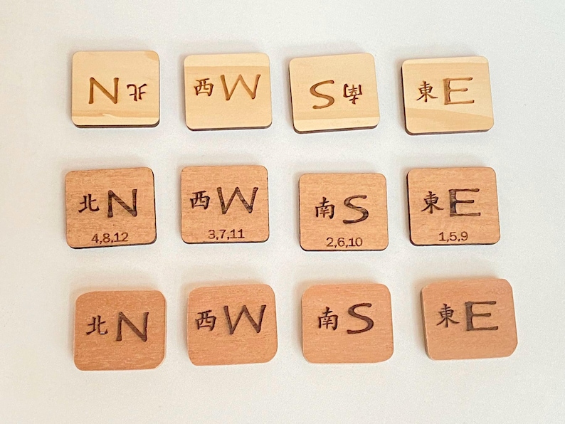 May include: Wooden square tiles with engraved compass directions in English and Chinese characters. Some tiles have numbers. The tiles are in shades of light and medium brown.