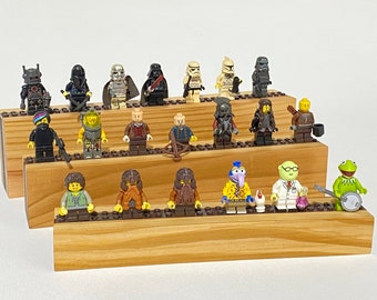 May include: A collection of 20 miniature Lego figures displayed on three wooden shelves. The figures include characters from Star Wars, The Muppets, and other popular franchises.