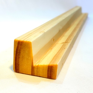 May include: A wooden shelf with a V-shaped groove, made from light-colored wood with visible grain.