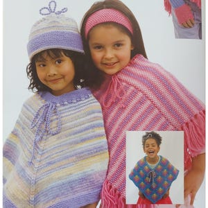 Może przedstawiać: Dwie dziewczyny w kolorowych, paskowanych ponczach z dzianiny. Jedna dziewczyna ma różową opaskę na głowie, a druga nosi fioletowo-biały beret. Dziewczyny uśmiechają się i patrzą w obiektyw.