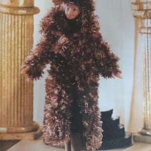 May include: A brown fuzzy coat with a matching hat. The coat is long and has a wide collar. The hat is a cloche style with a wide brim.