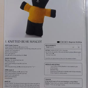 May include: Knitting pattern for a yellow and black knitted bear mascot. The pattern includes instructions for the body, arms, and head. The pattern also includes measurements for the finished bear, as well as a list of materials and needles needed.