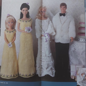 May include: Four dolls dressed in knitted wedding attire. The bride and groom are wearing white, while the bridesmaids are wearing yellow. The dolls are holding bouquets of flowers.