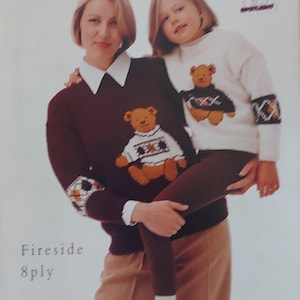 May include: A woman and a child wearing brown and white knitted sweaters with teddy bear designs. The sweaters are made with Patons Fireside 8ply yarn. The text "Teddy and Friends" is at the top of the image.