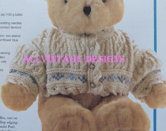 May include: A knitting pattern for a cardigan with scalloped edges and embroidered flowers. The pattern includes instructions for knitting the cardigan and a teddy bear wearing the finished cardigan.