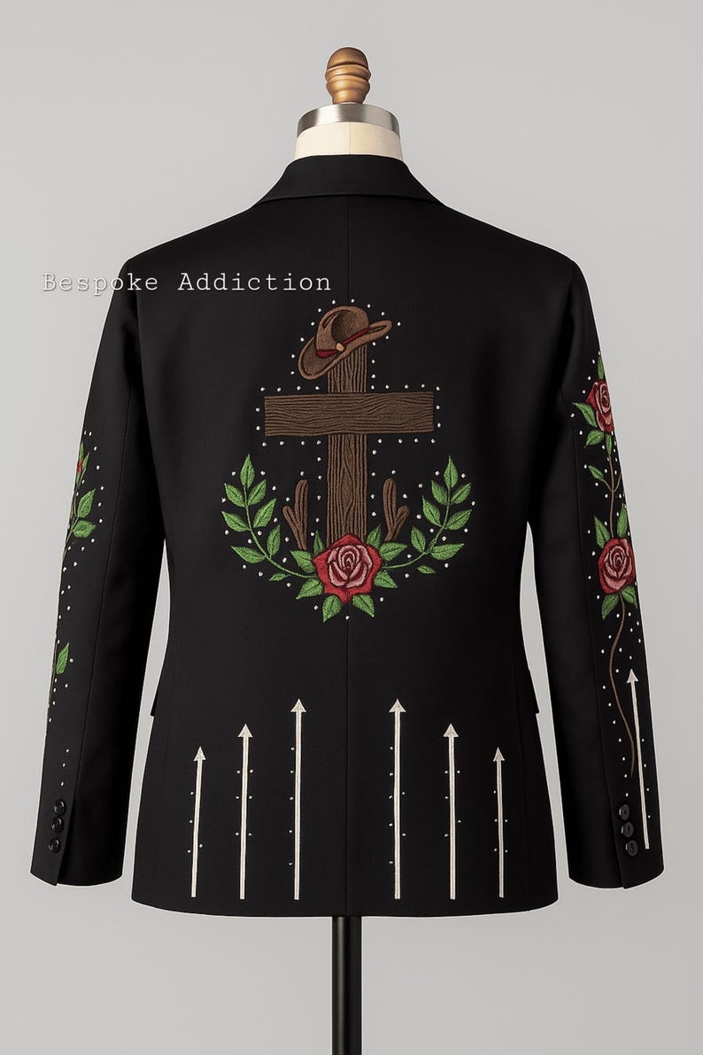 Puede incluir: Chaqueta negra con bordados. La espalda presenta una cruz, sombrero de vaquero, rosas y hojas. Flechas blancas apuntan hacia arriba. Las mangas tienen patrones florales y de puntos. El texto "Bespoke Addiction" es visible.